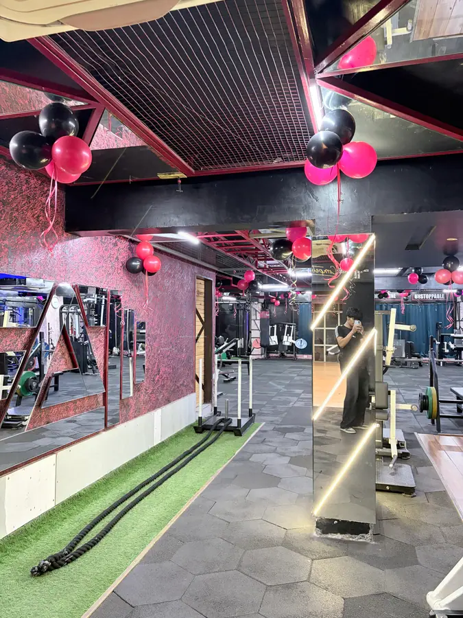 The weights floor beside the mirrored wall, with the turf lane running along the front