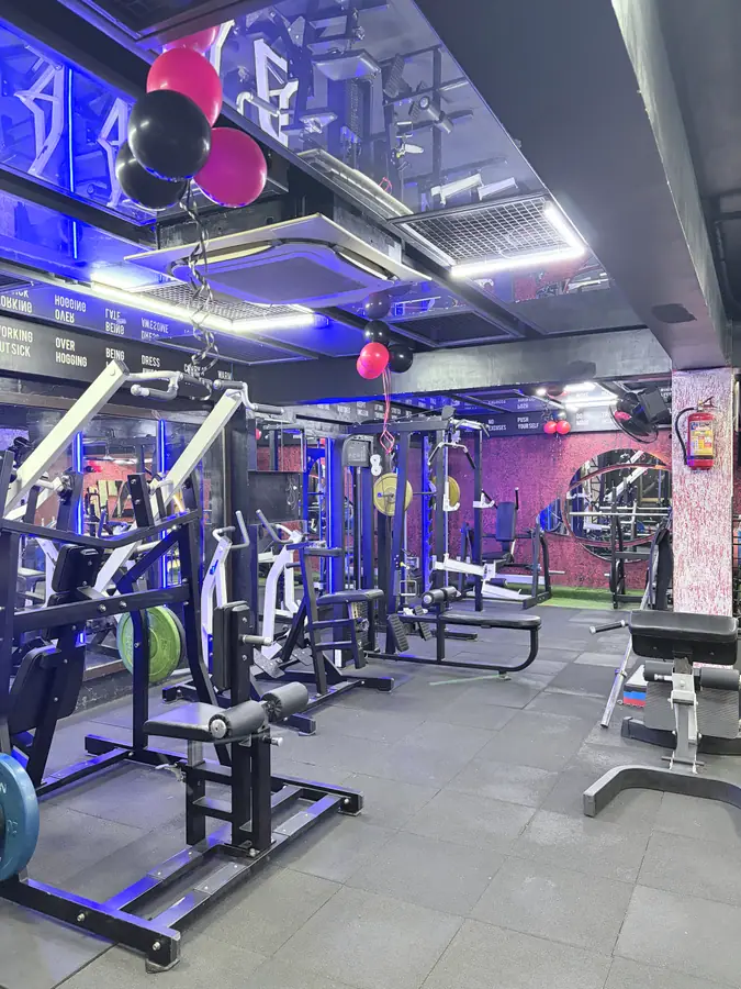 Cable machines and a lat pulldown station under blue light