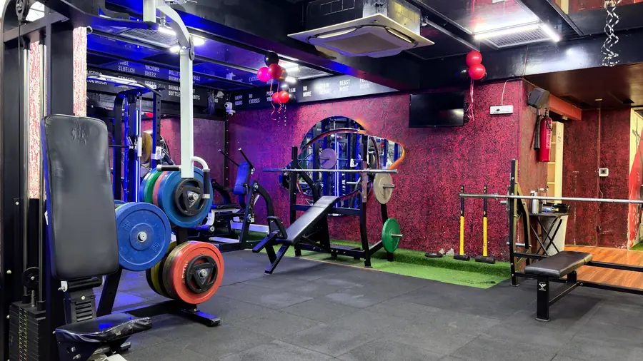 Benches and racks arranged around the central pillar of the strength floor