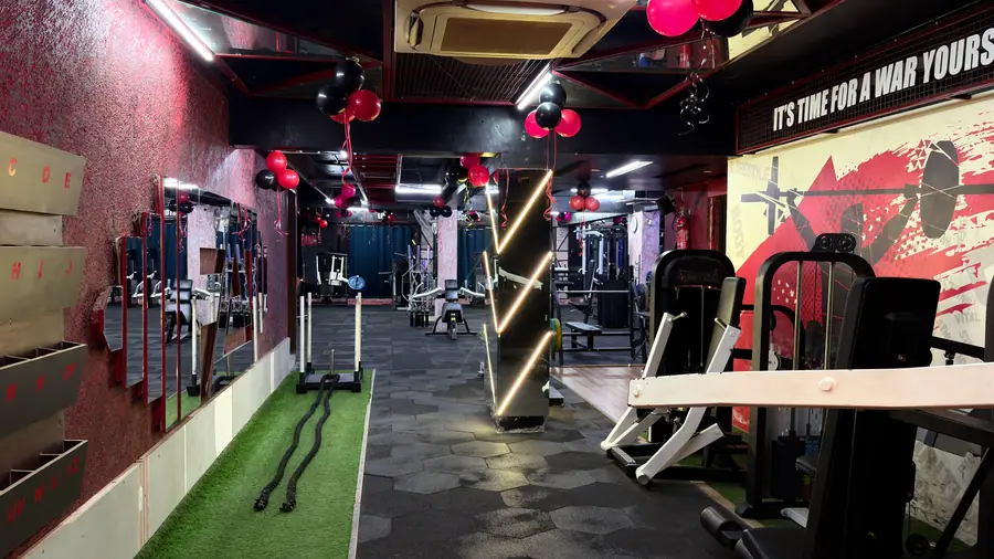 The strength floor at night, magenta walls under the violet ceiling strips