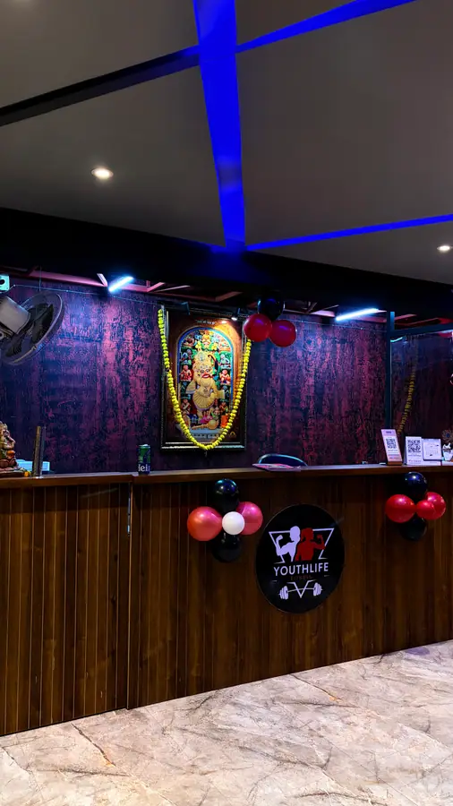 The Youthlife Fitness reception desk on the 7th floor, finished in wood with the logo behind it